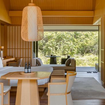 Mori Suite living area at Amanemu with wooden interior, dining table, and open doors leading to garden views.