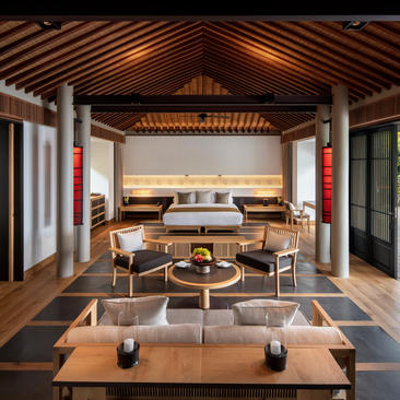 Principal bedroom at Amanoi with wooden ceiling, ocean views, and contemporary furnishings overlooking Vietnam's coastline.