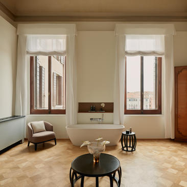 Bathroom in Coccina's apartment at Aman Venice, featuring pale walls, wooden flooring and minimalist furnishings.