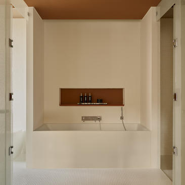 Baignoire de la suite Grand Canal à l'hôtel Aman Venice, avec murs en marbre clair et niche murale.