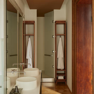 Bathroom della camera Sansovino all'Aman Venice, con doppio lavabo in ceramica bianca e specchi incorniciati in legno.