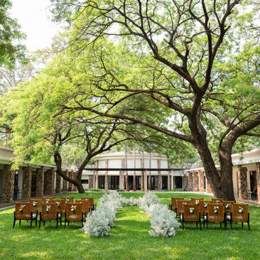 Amansara's central courtyard with manicured gardens and colonial-style pavilions shaded by mature trees.
