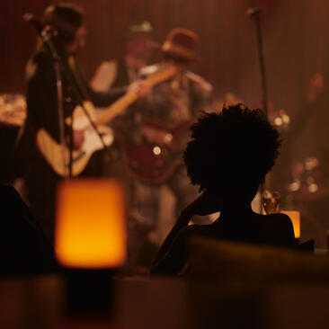 Silhueta de visitante ouvindo música ao vivo no clube de jazz do Aman New York.