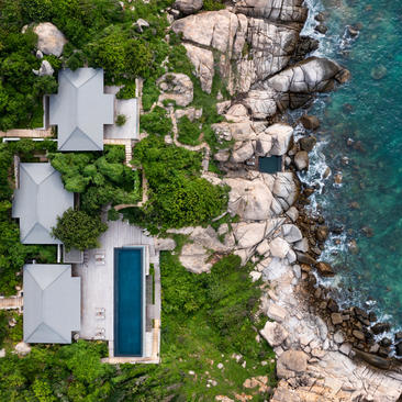 Aerial view of two-bedroom ocean pool residence at Amanoi with infinity pool overlooking turquoise sea and rocky coastline.
