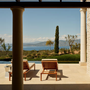 安缦卓熠度假村的豪华泳池别墅露台，配有木制座椅，俯瞰海景。