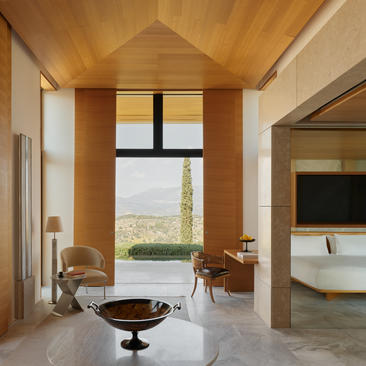 Interior de pabellón de alojamiento en Amanzoe con techo de madera, ventana panorámica y bañera independiente.
