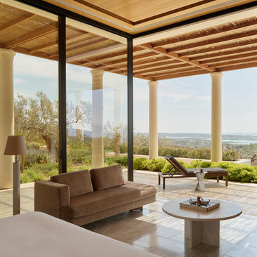 安缦卓熠度假村的别墅露台，配有现代布艺沙发、木质茶几，可俯瞰山景与海景。