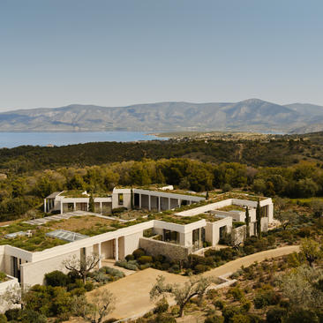 Villa en pierre blanche avec vue sur la baie, entourée de pinèdes, à Amanzoe.