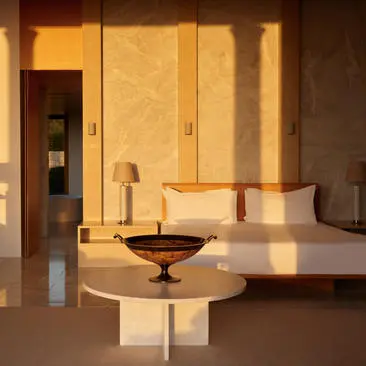 Villa living area at Amanzoe resort, with warm golden light filtering through timber screens and minimal furnishings.