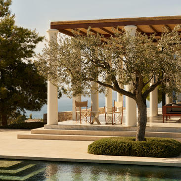 Villa terrace with wooden pergola and olive trees at Amanzoe resort.