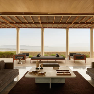 安缦卓熠度假村的别墅起居室，配有木质天花板和宽敞的落地窗，俯瞰广阔景观。