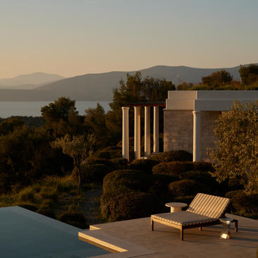 Villa with infinity plunge pool overlooking Aegean Sea at sunset, Amanzoe resort.