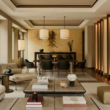 Sala de estar da Aman Suite no hotel Aman New York, com piano de cauda e sofás de linho claro.