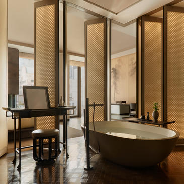 Deluxe Suite bathroom at Aman New York with freestanding soaking tub and vanity desk.