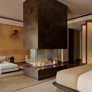 Grand Suite com lareira central e camas de ambos os lados no Aman New York hotel.