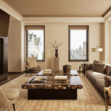 Soggiorno con tre camere da letto presso Aman New York, arredato con divani in tonalità neutre e tavolino centrale in marmo.