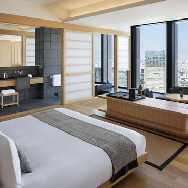 Grand Suite principal bedroom with king bed, floor-to-ceiling windows overlooking Tokyo, and modern ensuite at Aman Tokyo.