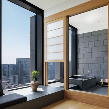Bathroom at Aman Tokyo with grey subway tiles, wooden frames, and floor-to-ceiling windows overlooking the city skyline.