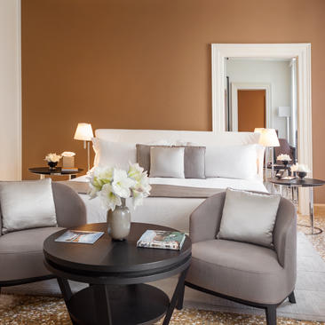Sala d'estar amb sofà gris, taula negra i mirall blanc a Aman Venice.