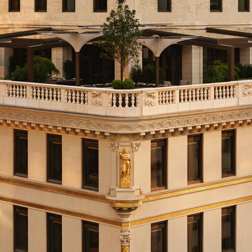 Exterior of the Crown Building at Aman New York, featuring classical columns and ornate stone detailing.