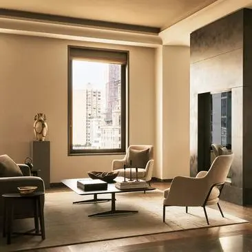 Serene living room at Aman New York with floor-to-ceiling windows overlooking the city skyline, neutral tones, and contemporary furnishings.