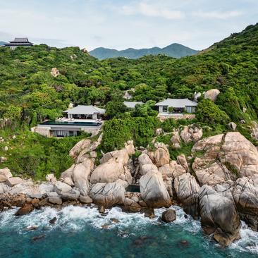 Amanoi residence perched on rocky coastal outcrop surrounded by lush Vietnamese jungle and turquoise waters.