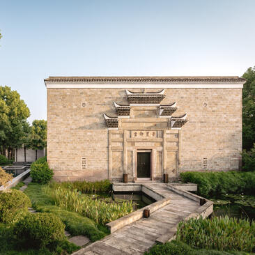Traditional Chinese pavilion with curved roof at Amanyangyun, framed by lush green landscaping.
