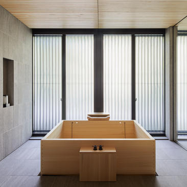 アマン京都のパビリオンにある木製浴槽と大きな窓からの自然光を取り入れた最小限の浴室空間。