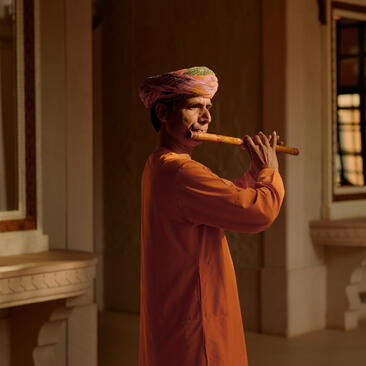 Musician playing a traditional wind instrument at Amanbagh, India.