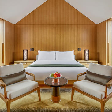 Ming courtyard suite bedroom at Amanyangyun with wooden panelled walls and symmetrical seating.