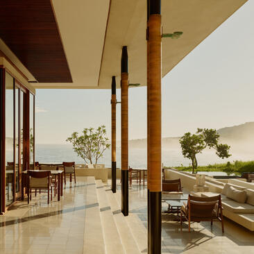 Terrace at Amanera resort with open-air seating, wooden columns, and views across Dominican landscape at sunset.