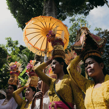 Amandari resort में Galungan Kuningan उत्सव के दौरान पीले रंग की पारंपरिक वेशभूषा में बालियन समुदाय।
