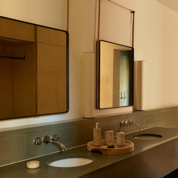 Amangiri suite bathroom with dual vanities, mirrors, and stone countertop.