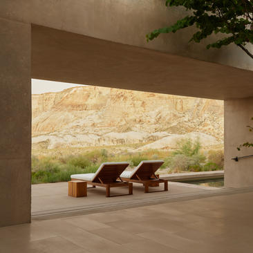Girijaala Suite at Amangiri with two wooden loungers facing desert landscape through open frame.