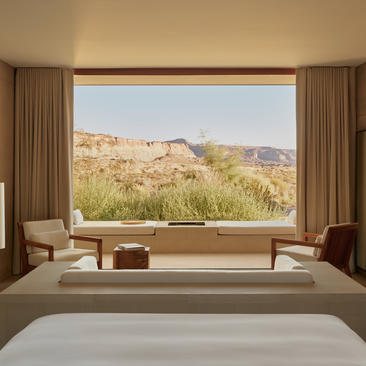 Desert suite bedroom at Amangiri with panoramic window framing canyon landscape.