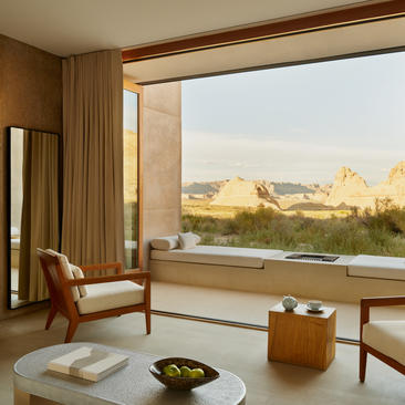 Orchard Suite at Amangiri with floor-to-ceiling windows overlooking desert landscape and comfortable seating area.