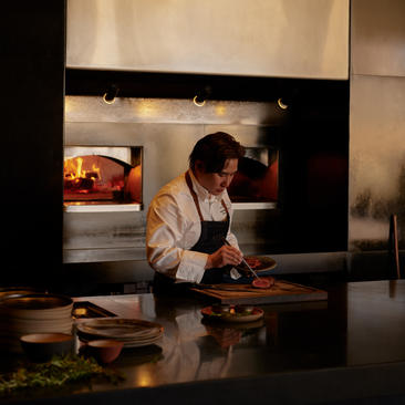 アマンギリのエグゼクティブシェフが、モダンなオープンキッチンで料理を準備している。