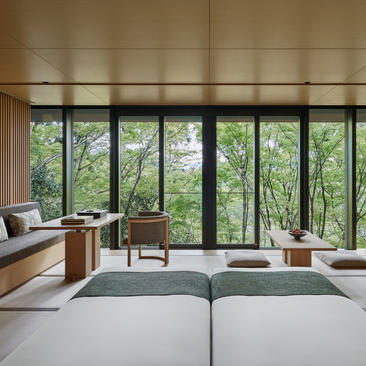 アマン京都のリゾートで、森を見渡す大きな窓と、シンプルで落ち着いた客室インテリア。