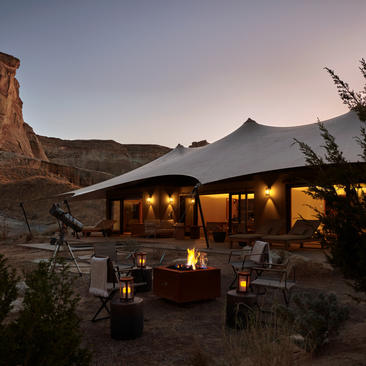 Two-bedroom pavilion at Amangiri with illuminated terrace overlooking desert landscape at dusk.