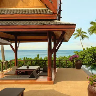 Deluxe ocean pool pavilion at Amanpuri, Thailand, with wooden shelter, lounge chairs, and coastal views.