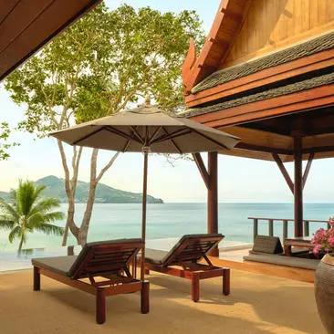 Ocean pool pavilion with wooden loungers and canopy overlooking the Andaman Sea at Amanpuri, Thailand.