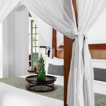 Pool Suite at Amantaka with sheer white drapes framing a serene bathing area and potted plant.