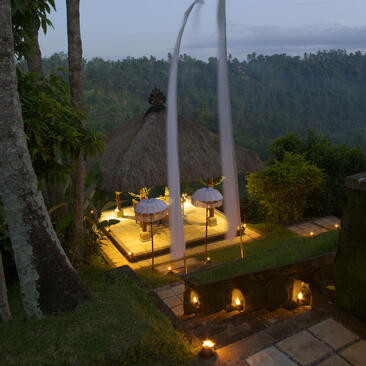 منطقة تناول الطعام في الهواء الطلق مضاءة بالشموع في أمانداري، منتجع في أوبود، بالي.