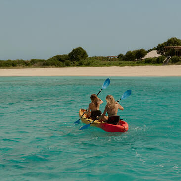 アマンヤラでのカヤック体験。浅瀬の透き通ったターコイズ色の海でカヤックを漕ぐ人々。