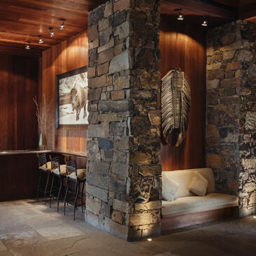 Entrance to Zinc Bar at Amangani, with stone walls, warm lighting, and seating areas.