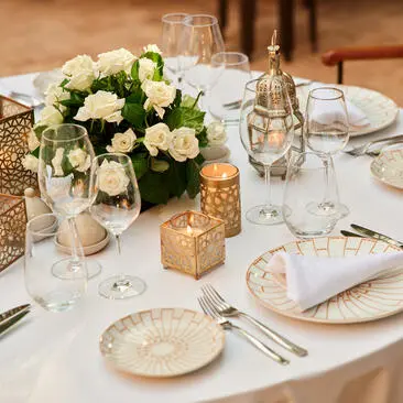 Tavolo da pranzo elegantemente preparato con fiori bianchi e verdi ad Amanjena resort.