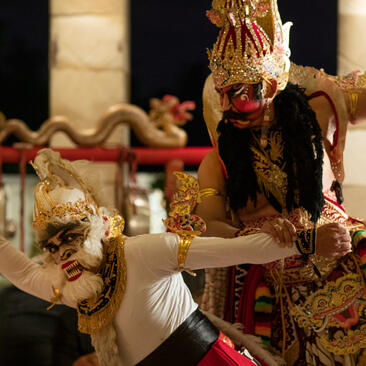 Ramayana dinner theatre performance at Amanjiwo, with elaborately costumed dancers in traditional Javanese dress against a dark background.