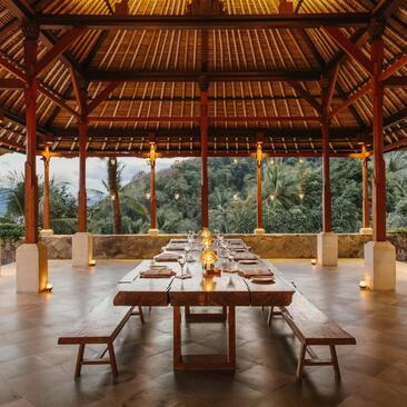 Table de récolte sous un pavillon ouvert à Amankila, Bali, avec vue sur les rizières.