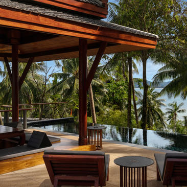 Pool pavilion at Amanpuri with wooden interior and water views through open sides.