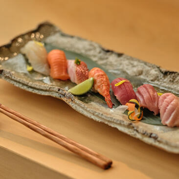 Assorted sashimi and nigiri sushi on a rectangular slate plate at Amanpuri resort's Nama dining venue.